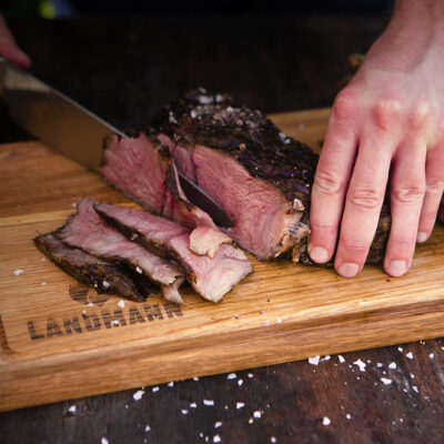 Ein medium gebratenes Steak wird auf einem LANDMANN Holzbrett angeschnitten