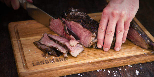 Ein medium gebratenes Steak wird auf einem LANDMANN Holzbrett angeschnitten